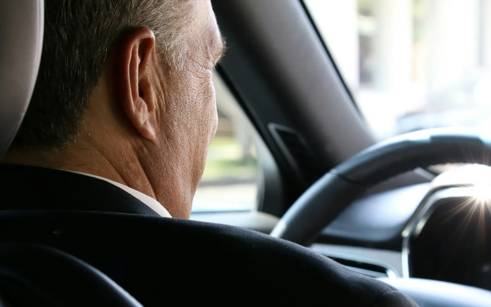 Chauffeur en costume au volant
