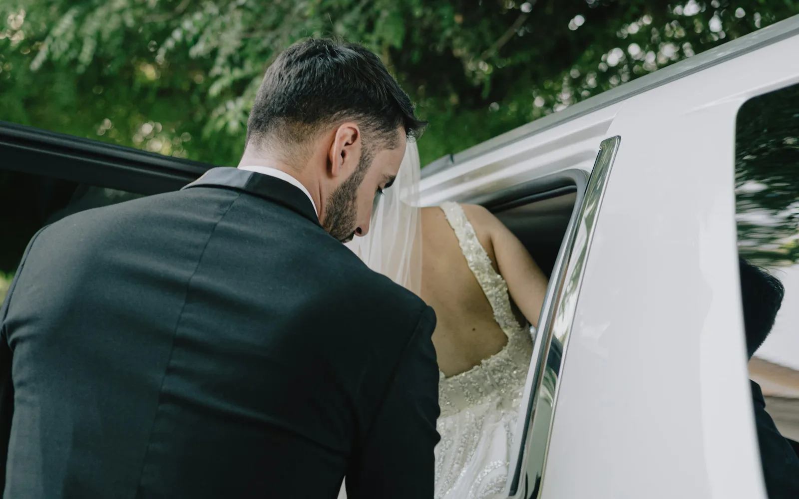 Les mariés montant dans la voiture du cortège